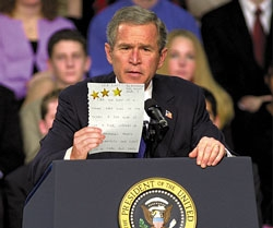 Bush holds up a Dayton, OH, fourth-grader's gold-star-adorned book report on Ferdinand Magellan.